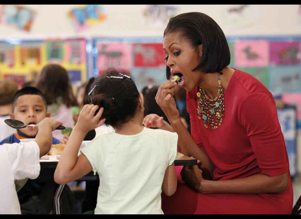 First lady Michelle Obama eats a piece of broccoli as she sits down to eat with students during their visit to New Hampshire Elementary School, Mexican First Lady Margarita Zavala, not shown, Wednesday, May 19, 2010, in Silver Spring, Md. The school, which was awarded the USDA's  Healthier US School Challenge Silver Award in 2009, serves more than 400 Pre-K, Head Start, first and second grade students, many who come from Central America, South America, and other countries. (AP Photo/Pablo Martinez Monsivais)