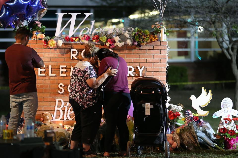 From left, Albert Martinez, Elida Gonzales, Amber Gonzales and Nyla Martinez, in her stroller, visit the memorial at Uvalde's Robb Elementary on May 25, the day after 19 children and two adults were killed in the deadliest school shooting in Texas history.