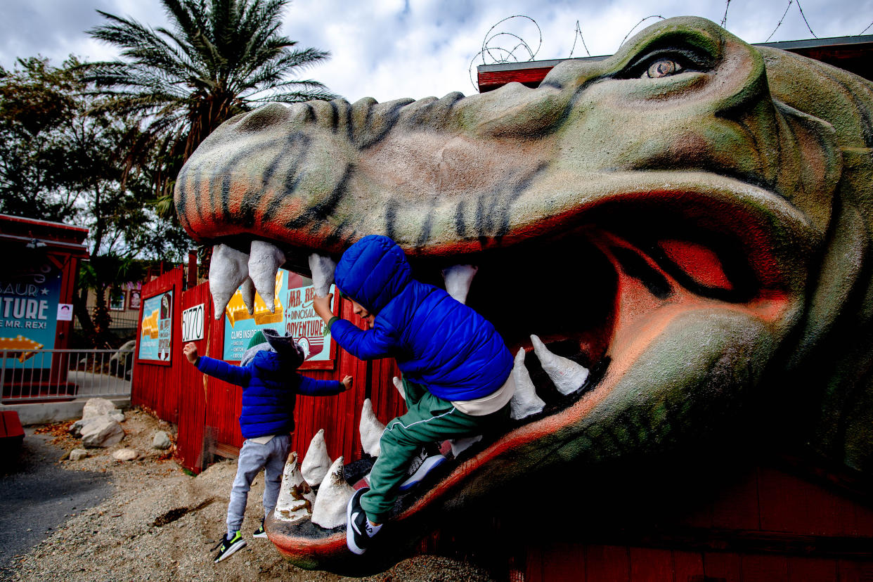 CABAZON, CA - JANUARY 27: Omar Abouzahr, 5, front, and brother Fahed, 7, of Corna play in the mouth of a concrete dinosaur at the Cabazon Dinosaurs attraction in Cabazon on Wednesday, Jan. 27, 2021. (Photo by Watchara Phomicinda/MediaNews Group/The Press-Enterprise via Getty Images)