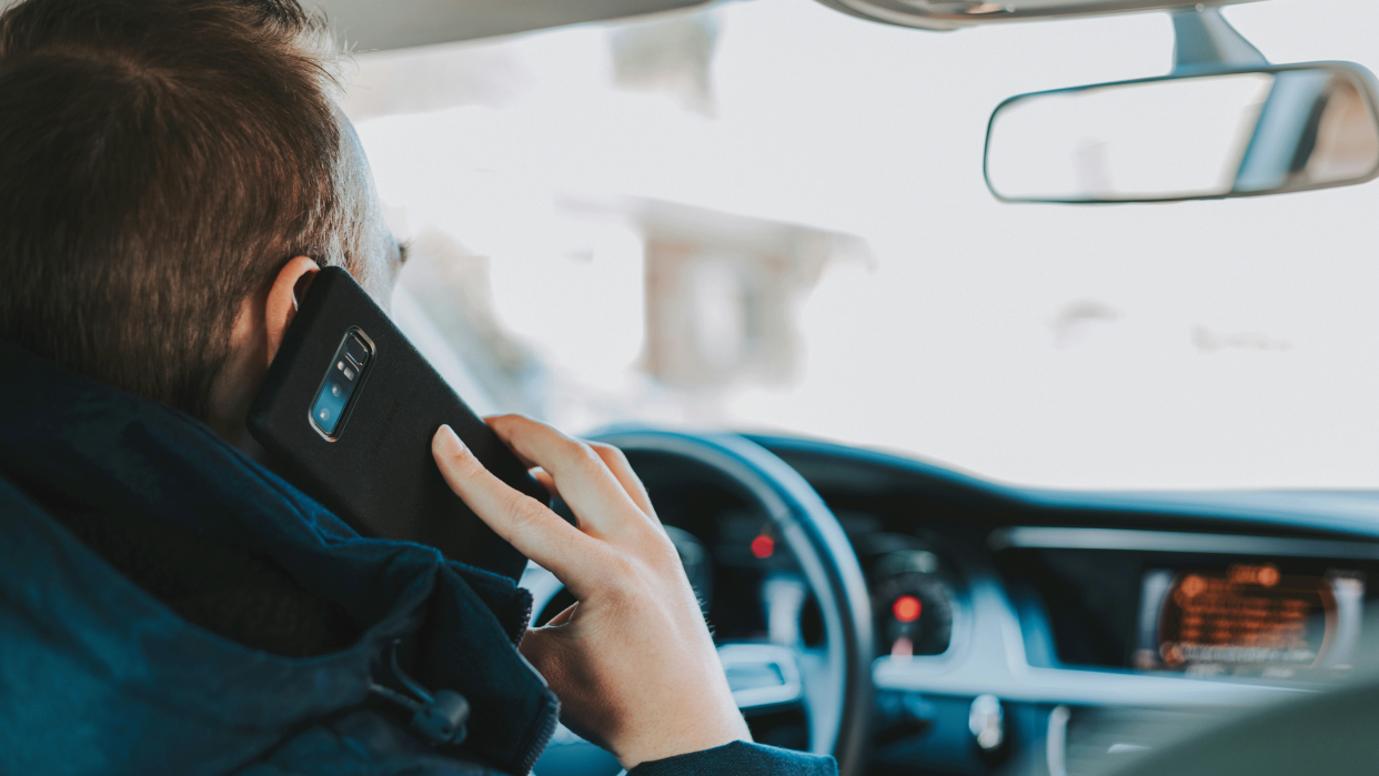  Man driving while using his phone. 