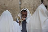 An ultra-Orthodox Jewish man blows a shofar, a musical instrument made from an animal horn, as he prays ahead of the Jewish new year at the Western Wall, the holiest site where Jews can pray in Jerusalem's old city, Wednesday, Sept. 16, 2020. A raging coronavirus outbreak is casting a shadow over the normally festive Jewish New Year. (AP Photo/Sebastian Scheiner)