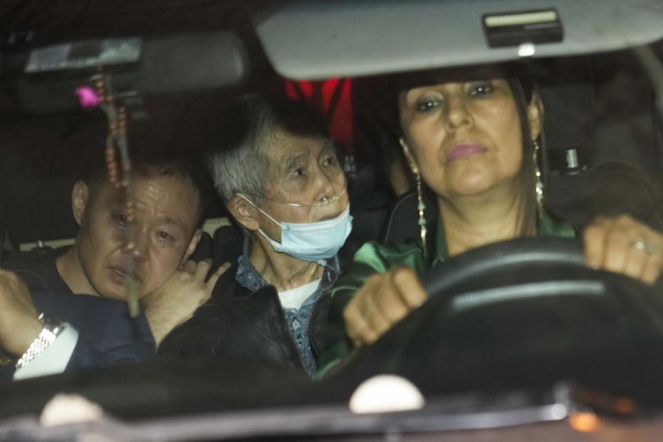 Peru's former President Alberto Fujimori, 85, center, is driven out of prison by his children Kenji, left, and Keiko, not seen, after being released from prison in Callao, Peru, Wednesday, Dec. 6, 2023. The country's constitutional court ordered an immediate humanitarian release on Tuesday for the former leader who was serving a 25-year sentence for human rights abuses. (AP Photo/Martin Mejia)