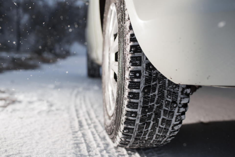 Closeup of car tires in winter. the first snow in late autumn.