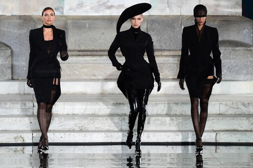 Russian model Irina Shayk (L) and US model Bella Hadid (C) present a creation during the presentation of French fashion editor Carine Roitfeld's CR Runway concept with Italian luxury retailer LuisaViaRoma, on the Piazzale Michelangelo esplanade on June 13, 2019 within the Pitti Immagine Uomo fashion fair in Florence. - The show features some 90 fall 2019 mens and womens looks curated by French fashion editor Carine Roitfeld, which will then begin retailing on LuisaViaRomas international website, rolling out in various drops throughout the year. (Photo by Miguel MEDINA / AFP)MIGUEL MEDINA/AFP/Getty Images ORIG FILE ID: AFP_1HH8VU