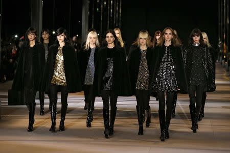 Models present creations by French designer Hedi Slimane as part of his Fall/Winter 2014-2015 women's ready-to-wear collection for fashion house Saint Laurent Paris during Paris Fashion Week March 3, 2014. REUTERS/Gonzalo Fuentes
