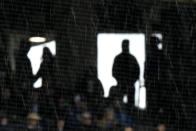 Fans shelter from rain as they watch from a concourse during the third inning of a baseball game between the Kansas City Royals and the Toronto Blue Jays Thursday, April 25, 2024, in Kansas City, Mo. (AP Photo/Charlie Riedel)