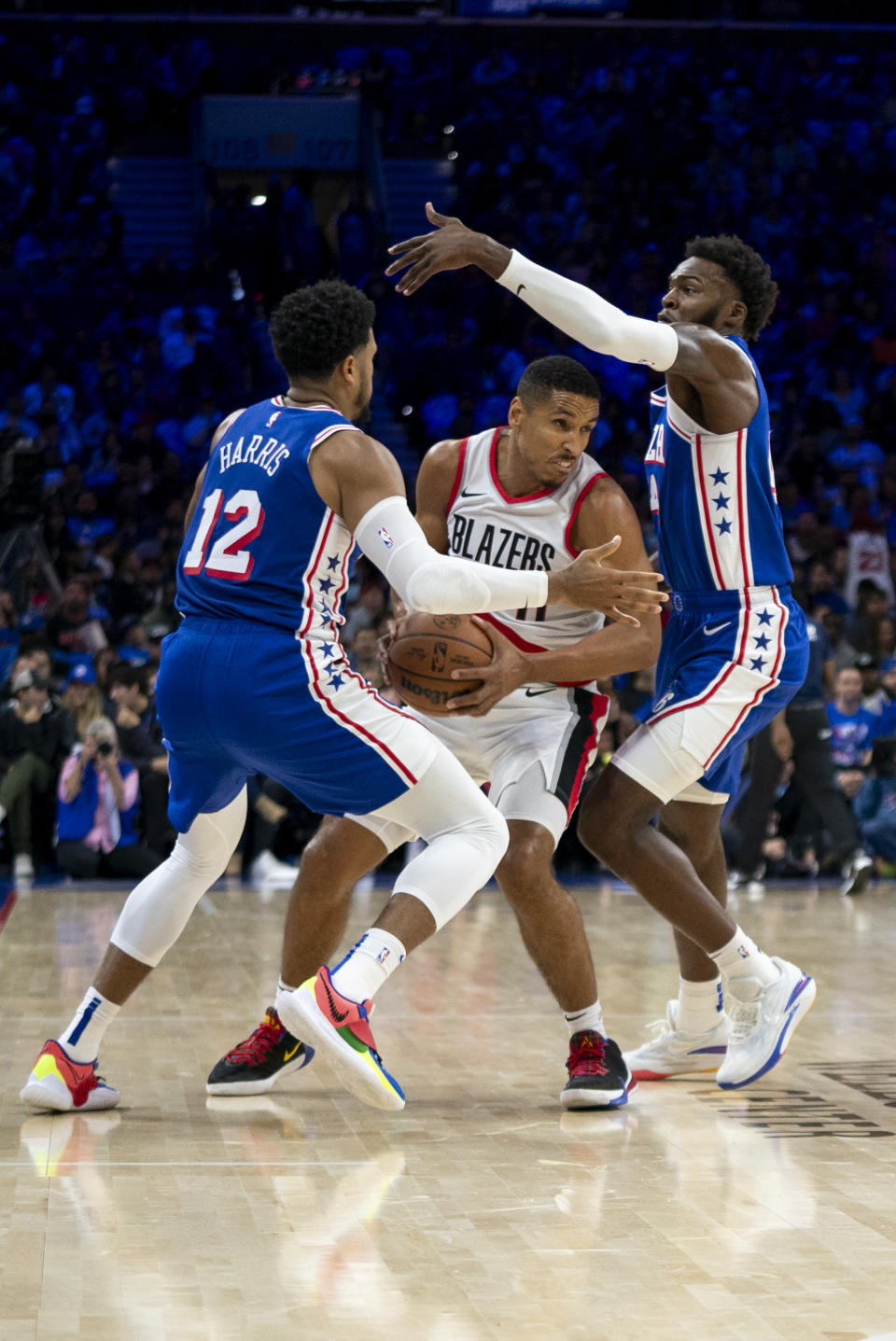 Portland Trail Blazers' Malcolm Brogdon, center, tries to make his move while being guarded by Philadelphia 76ers' Paul Reed, right, and Tobias Harris, left, during the first half of an NBA basketball game, Sunday, Oct. 29, 2023, in Philadelphia. (AP Photo/Chris Szagola)