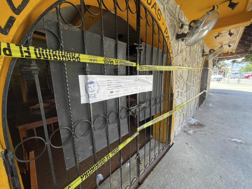 Police security tape covers the entrance of a restaurant the day after a fatal shooting in Tulum, Mexico, Friday, Oct. 22, 2021. Two foreigners were killed and three wounded in a shooting in the Mexican Caribbean resort town of Tulum. (AP Photo/Christian Rojas)