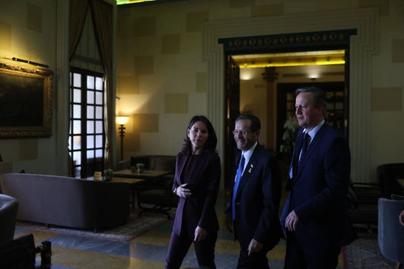 Annalena Baerbock (L), the German Foreign Minister, and David Cameron (R), the British Foreign Secretary, arrive for a meeting with Israeli President Isaac Herzog (C) at a hotel in Jerusalem.  Ilia Yefimovich/dpa