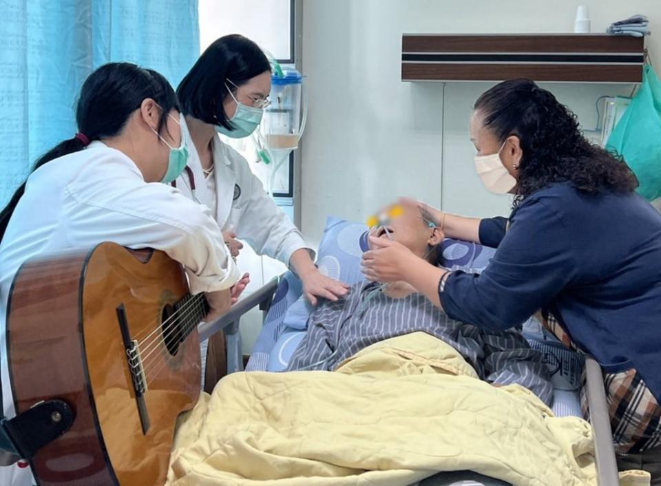 音樂治療師江亦薇（左一）在高榮南院安寧病房，以輕快節奏歌曲為九十歲老榮民城伯伯進行音樂療癒，讓其在生病過程中度過短暫的美好時光。 （高榮南院提供）