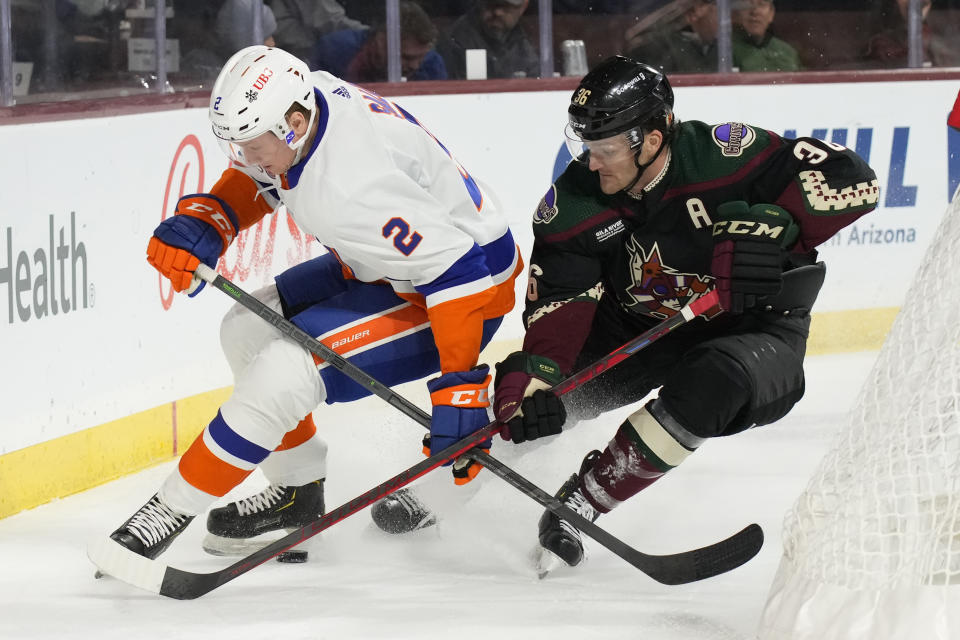 New York Islanders defenseman Robin Salo (2) and Arizona Coyotes right wing Christian Fischer (36) fight for the puck in the third period during an NHL hockey game, Friday, Dec. 16, 2022, in Tempe, Ariz. Arizona won 5-4. (AP Photo/Rick Scuteri)