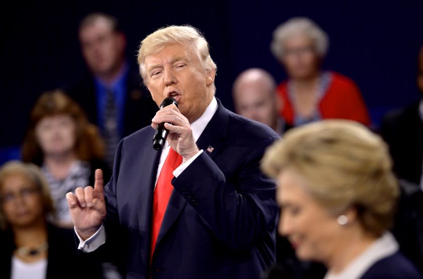 Republican presidential nominee Donald Trump speaks as Democratic presidential nominee Hillary Clinton listen during the second presidential debate at Washington University in St. Louis, Sunday, Oct. 9, 2016. (Saul Loeb/Pool via AP)