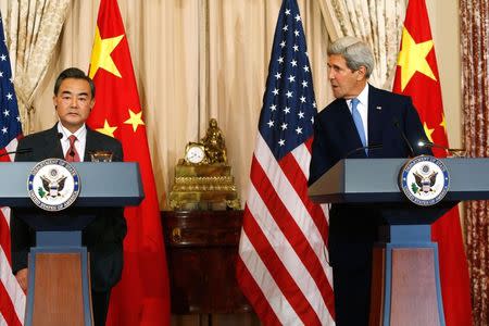 U.S. Secretary of State John Kerry (R) delivers remarks as China's Foreign Minister Wang Yi (L) looks on, before their meeting at the State Department in Washington October 1, 2014. REUTERS/Jonathan Ernst