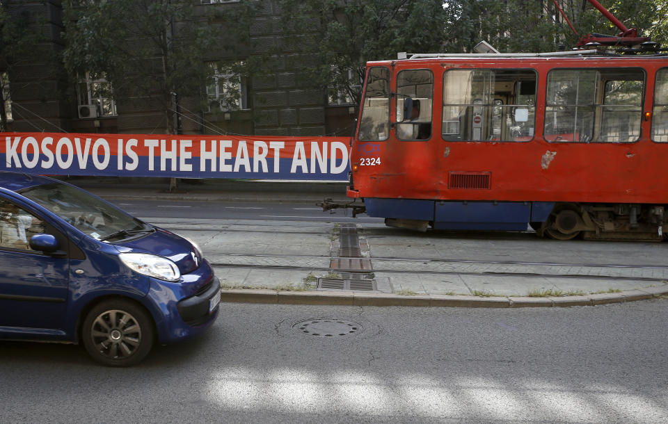 A tram car passes by a billboard reading: ''Kosovo is the heart and soul of Serbia'' placed on a street in front of the government building in Belgrade, Serbia, Wednesday, Sept. 2, 2020. Serbian President Aleksandar Vucic and Kosovo Prime Minister Avdullah Hoti will meet at the White House on Thursday and Friday. (AP Photo/Darko Vojinovic)