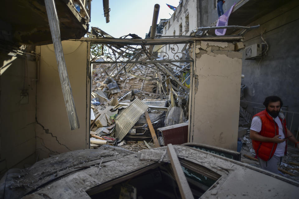 A man walks near to damage a day after shelling by Armenian's artillery during fighting over the separatist region of Nagorno-Karabakh, in Ganja, Azerbaijan, Monday, Oct. 12, 2020. Armenia and Azerbaijan on Monday have accused each other of attacks over the separatist territory of Nagorno-Karabakh despite a cease-fire deal brokered by Russia in an effort to end the worst outbreak of hostilities in decades. (AP Photo)