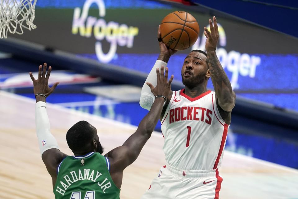 Dallas Mavericks forward Tim Hardaway Jr. (11) defends against a shot by Houston Rockets guard John Wall (1) during the second half of an NBA basketball game in Dallas, Saturday, Jan. 23, 2021. (AP Photo/Tony Gutierrez)