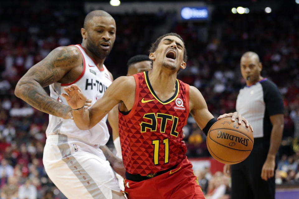 Atlanta Hawks guard Trae Young (11) reacts as he drives past Houston Rockets forward PJ Tucker, left, during the first half of an NBA basketball game, Saturday, Nov. 30, 2019, in Houston. (AP Photo/Michael Wyke)