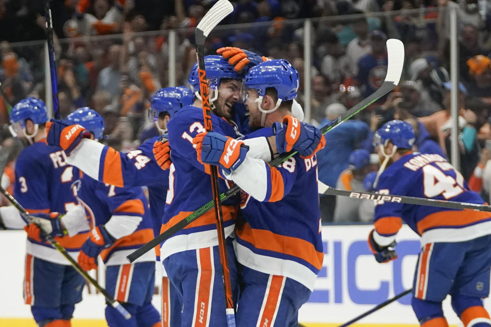 New York Islanders' Mathew Barzal (13) celebrates with Anthony Beauvillier (18) after Beauvillier scored a goal during the overtime period of Game 6 of an NHL hockey semifinals against the Tampa Bay Lightning Wednesday, June 23, 2021, in Uniondale, N.Y. The Islanders won 3-2. (AP Photo/Frank Franklin II)