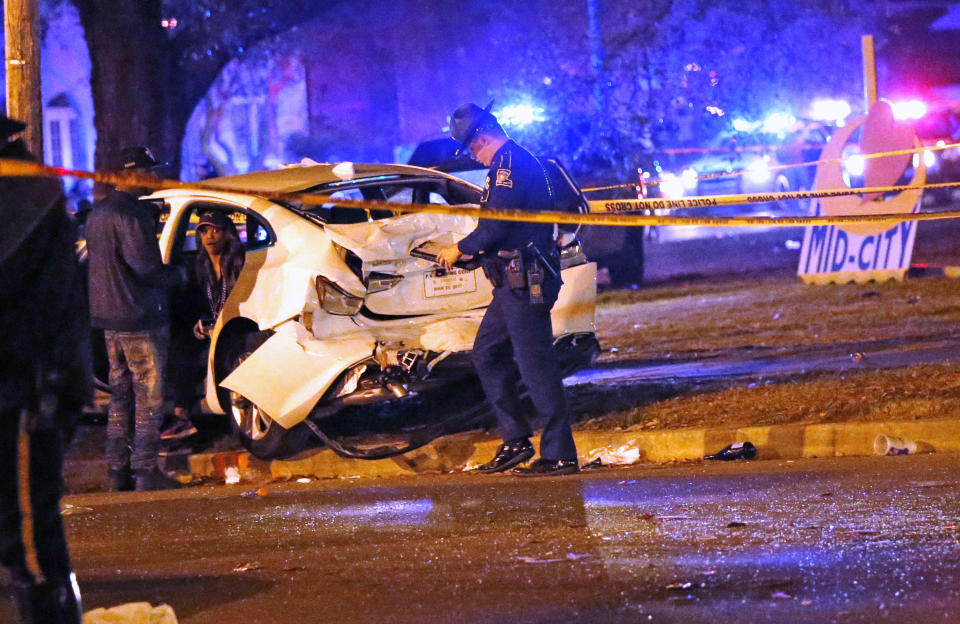 Police talk to a man sitting in a car that was struck by a pickup truck, that slammed into a crowd and other vehicles, causing multiple injuries, during the Krewe of Endymion parade in New Orleans, Saturday, Feb. 25, 2017. (AP Photo/Gerald Herbert)