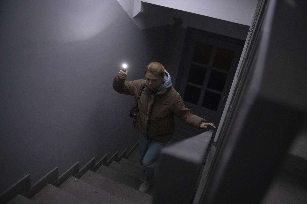 Anastasia Pyrozhenko, 25, climbs the stairs in her multi-storey apartment building in Kyiv, Ukraine, Sunday, Nov. 20, 2022. The lack of electricity turned Anastasia Pyrozhenko’s apartment into a deathtrap. Without electricity, there’s no water and no way to cook food, and the woman and her husband won’t even have time to run to the shelter from their 21st floor in the event of missile strikes, because the elevator isn’t working. (AP Photo/Andrew Kravchenko)