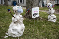 Two snowmen, six feet apart for social distancing, stand in the front yard of the Mack home in Kalamazoo, Michigan on Tuesday, March 24, 2020. Five-year-old twin boys Ricky and Charlie made the snowmen from a small amount of snow that fell overnight on Sunday. (Kendall Warner/Kalamazoo Gazette via AP)