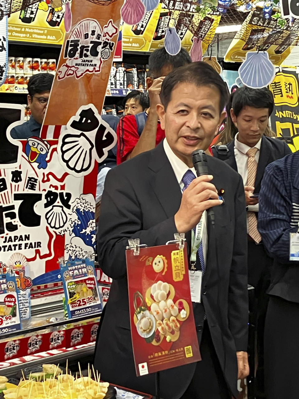 Japanese Agriculture Minister Ichiro Miyashita attends an event at Japanese store, Don Don Donki in Kuala Lumpur Wednesday, Oct. 4, 2023 to promote the safety and deliciousness of Japanese scallops to shoppers. Japan hopes to resolve the issue of China's ban on its seafood within the scope of the World Trade Organization ambit and will hold food fairs overseas to bolster seafood exports amid safety concerns over the release of treated water from the Fukushima Daiichi nuclear plant, Miyashita said Wednesday. (AP Photo/Eileen Ng)