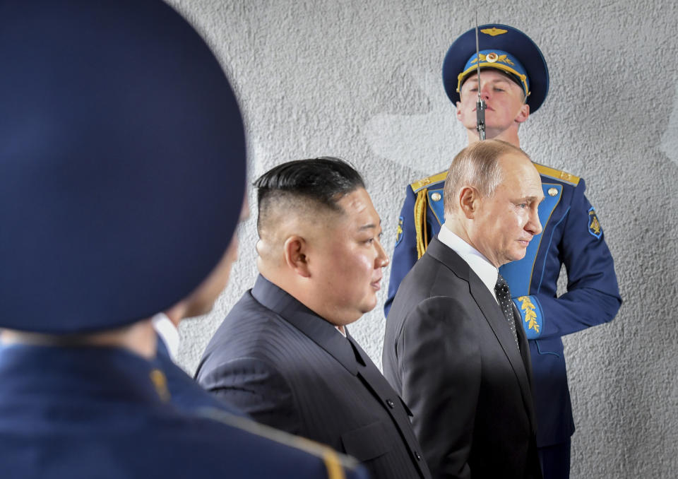 FILE - In this Thursday, April 25, 2019 file photo, President Vladimir Putin and North Korean leader Kim Jong Un, center, walk past honor guard officers during their meeting in Vladivostok, Russia. A plunging standard of living, a weak leader in Boris Yeltsin, thug businessmen and budding oligarchs fighting for control of state-owned businesses opened the way for Putin. (Yuri Kadobnov/Pool Photo via AP, File)