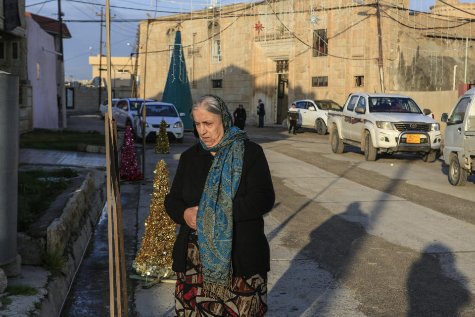 In this Jan. 18, 2019 photo, a woman walks in from of the Mart Shmony Orthodox Church in Bartella, Iraq. Two years after it was liberated from Islamic State militants, only a fraction of Christian residents have returned to Bartella. Many fear intimidation by the town’s population of Shabak, a Shiite Muslim ethnic group who dominate the militias that now run Bartella. (AP Photo/Fay Abuelgasim)