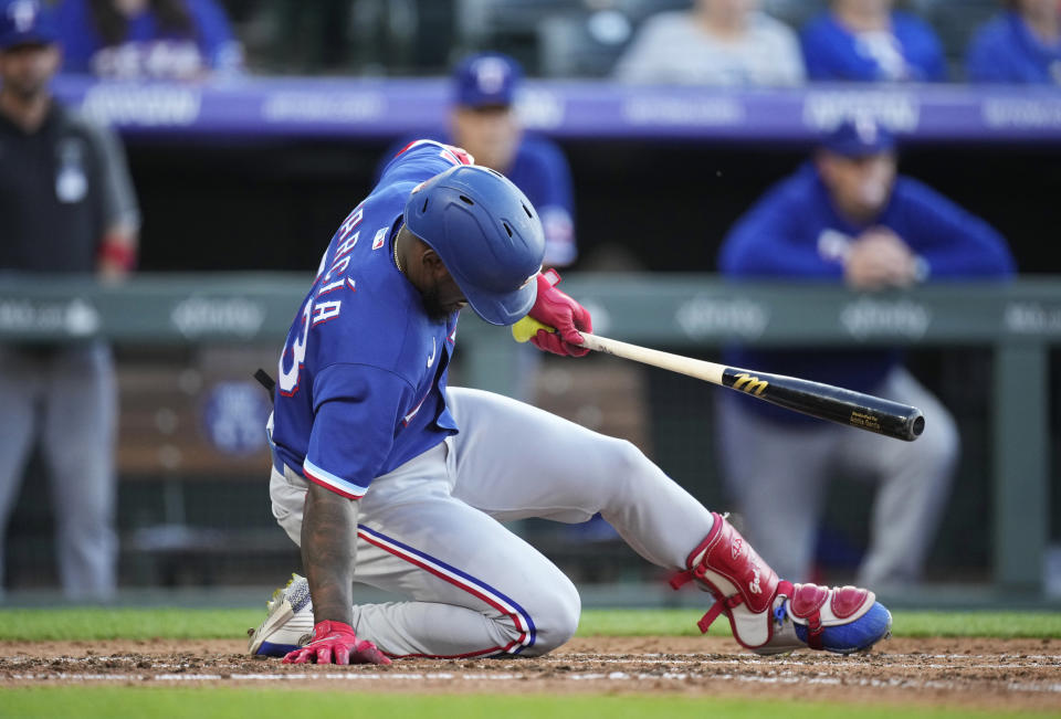 Texas Rangers' Adolis Garcia falls in the batter's box after swinging at a pitch from the Colorado Rockies during the third inning of a baseball game Wednesday, June 2, 2021, in Denver. (AP Photo/David Zalubowski)