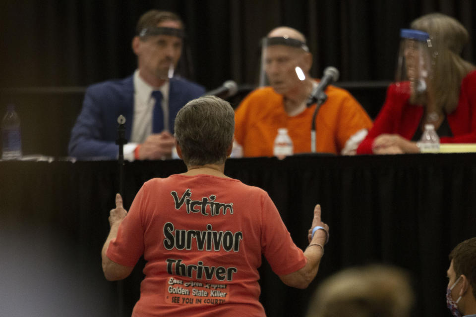 Jane Carson-Sandler, a 1976 rape victim of Golden State Killer Joseph James DeAngelo, stands and gives a double thumbs -up to agree with a prosecutor's statement about part of DeAngelo's anatomy, during a court hearing in Sacramento, Calif., Monday, June 29, 2020. DeAngelo, 74, pleaded guilty to 13 counts of murder and multiple other charges 40 years after a sadistic series of assaults and slayings in California. Due to the large numbers of people attending, the hearing was held at a ballroom at Sacramento State University to allow for social distancing. (AP Photo/Rich Pedroncelli)