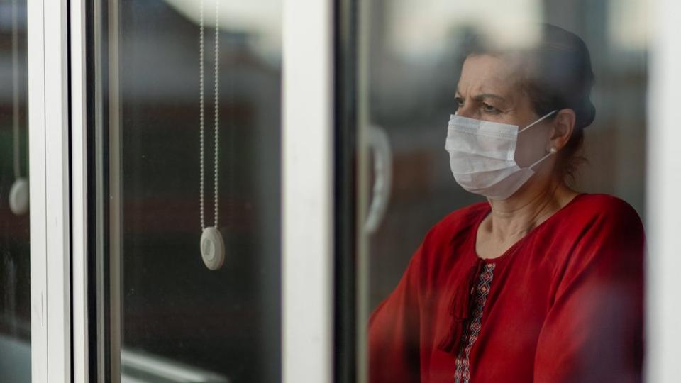 Mujer mira por una ventana