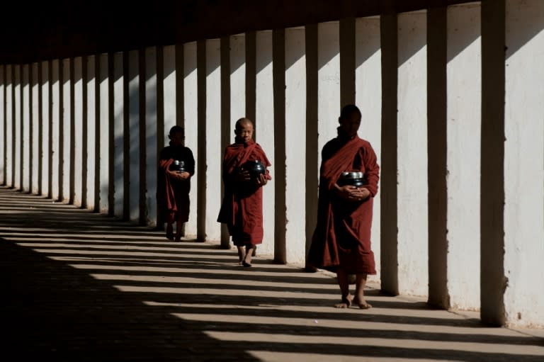 Buddhist monks walk inside a pagoda in Bagan