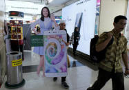 A salesperson carries an OPPO smartphone banner of Indonesia's filmstar Chelsea Islan at ITC Roxymas shopping mall in Jakarta, Indonesia, September 22, 2016. REUTERS/Beawiharta