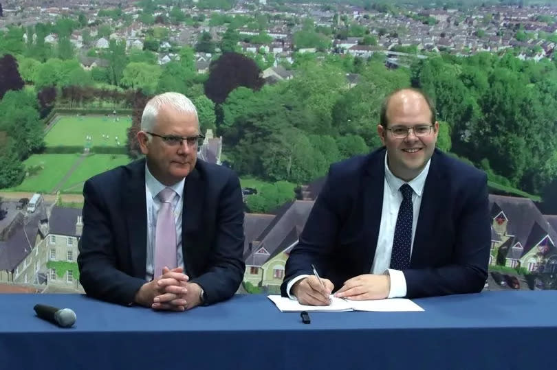 Jonathan Ash-Edwards (right) signs a declaration as he becomes Hertfordshire's second-ever police and crime commissioner, overseen by returning officer Jeff Stack (left)