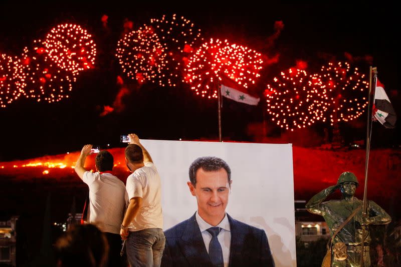 Supporters of of Syria's President Bashar al-Assad celebrate after the results of the presidential election announced that he won a fourth term in office, in Damascus