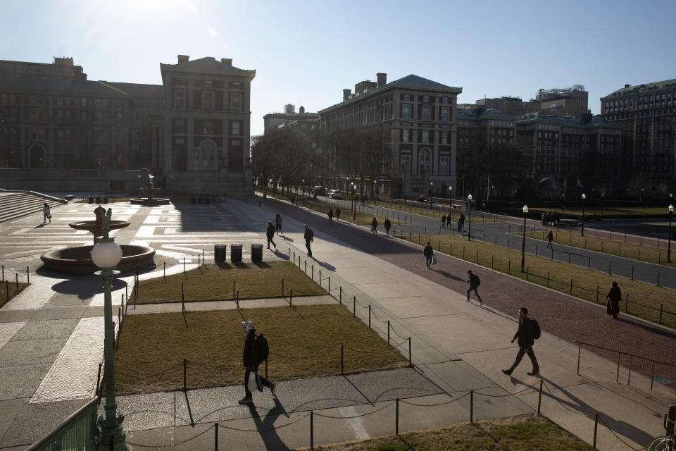 People walk on the Columbia University campus, Monday, March 9, 2020, in New York. The Ivy League school is canceling two days of classes this week because a person at the New York school is under quarantine from the rapidly spreading coronavirus, according to university president Lee Bollinger. (AP Photo/Mark Lennihan)