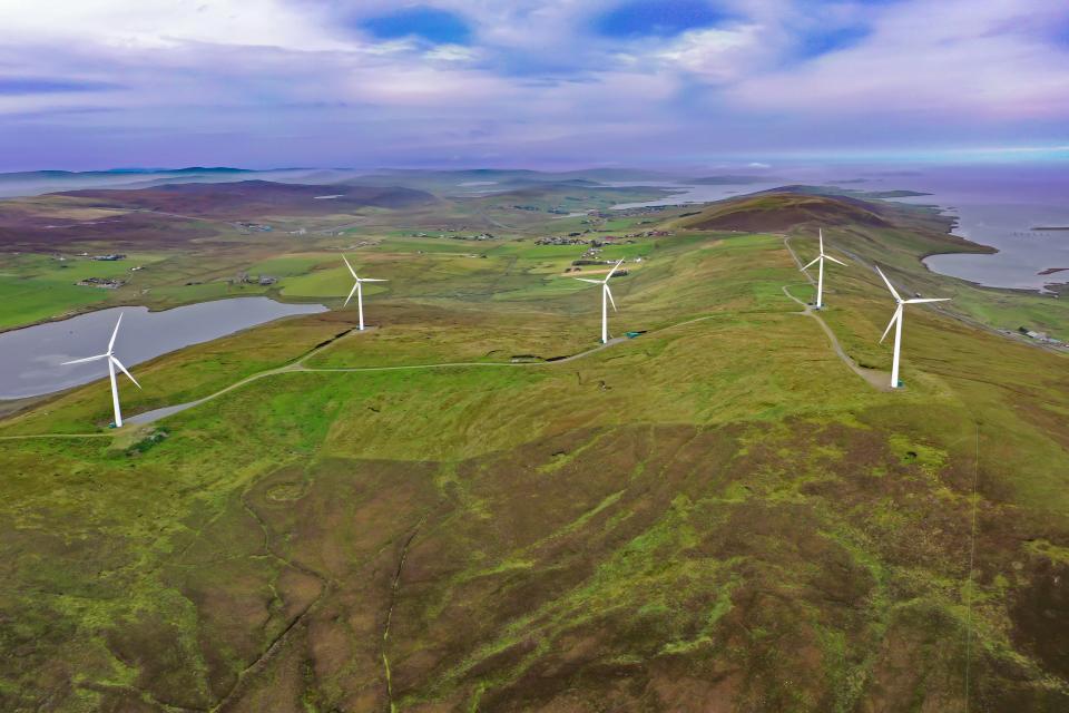 An overhead view of wind turbines near the coast.