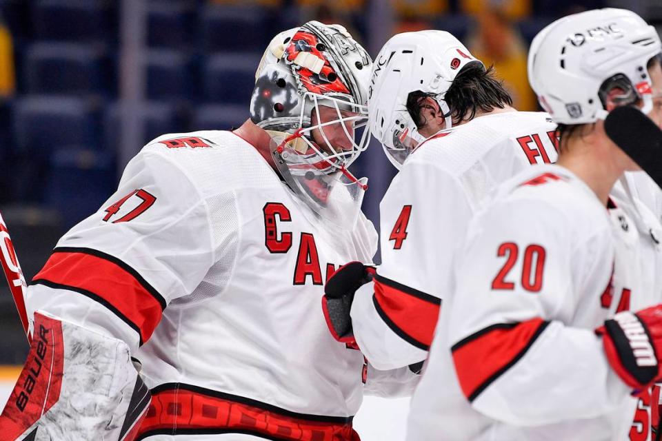 Carolina Hurricanes goaltender James Reimer (47) celebrates defeating the Nashville Predators 4-2 with defenseman Haydn Fleury (4) after an NHL hockey game in Nashville, Tenn., Monday, Jan. 18, 2021. (Andrew Nelles/The Tennessean via AP)