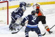 Winnipeg Jets goaltender Laurent Brossoit (39) saves a shot by Anaheim Ducks' Jakob Silfverberg (33) as Jets' Dylan DeMelo (2) defends during second-period NHL hockey game action in Winnipeg, Manitoba, Friday, March 15, 2024. (John Woods/The Canadian Press via AP)