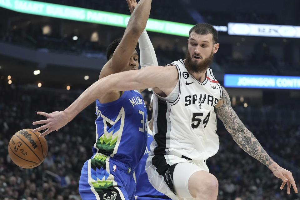 San Antonio Spurs' Sandro Mamukelashvili passes around Milwaukee Bucks' Giannis Antetokounmpo during the first half of an NBA basketball game Wednesday, March 22, 2023, in Milwaukee. (AP Photo/Morry Gash)