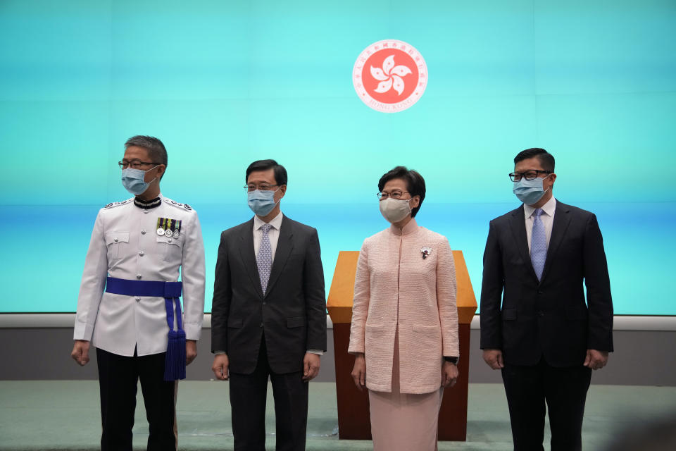 Hong Kong's Chief Executive Carrie Lam, second right, poses with Chief Secretary John Lee, second left, Secretary for Security Chris Tang, and Commissioner of Police Raymond Siu during a news conference in Hong Kong, Friday, June 25, 2021. China on Friday promoted Hong Kong’s top security official to the territory’s No. 2 spot as Beijing continues to clamp down on free speech and political opposition. (AP Photo/Kin Cheung)