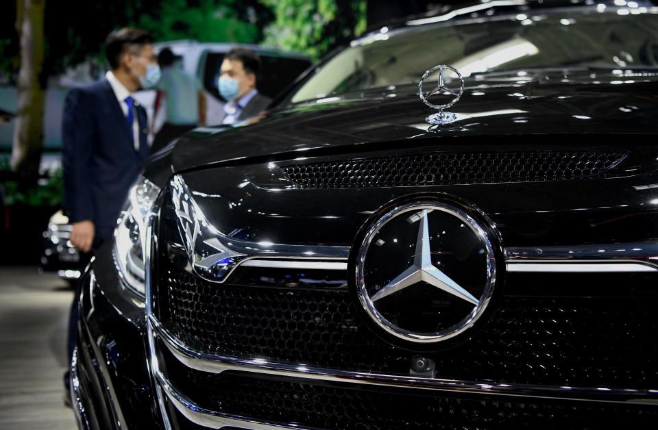 Visitors stand beside a Mercedez-Benz V-Class car displayed at the Beijing Auto Show in Beijing on September 26, 2020. (Photo by Noel CELIS / AFP) (Photo by NOEL CELIS/AFP via Getty Images)