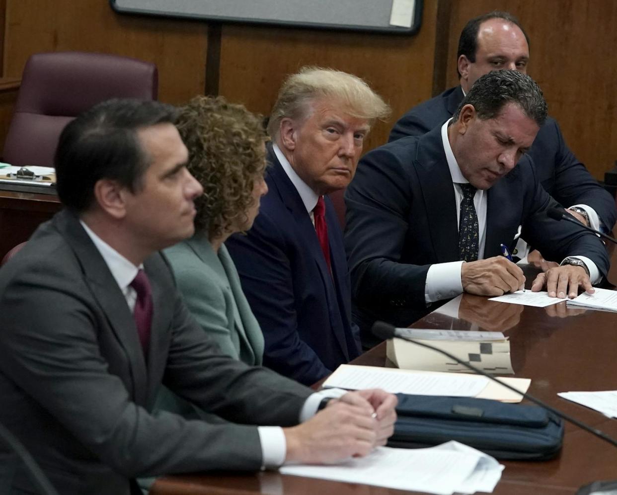 Former President Donald Trump sits with his attorneys inside a Manhattan courtroom during his arraignment in April 2023. <a href="https://www.gettyimages.com/detail/news-photo/former-u-s-president-donald-trump-sits-with-his-attorneys-news-photo/1479816537?adppopup=true" rel="nofollow noopener" target="_blank" data-ylk="slk:Timothy A. Clary-Pool/Getty Images;elm:context_link;itc:0;sec:content-canvas" class="link ">Timothy A. Clary-Pool/Getty Images</a>