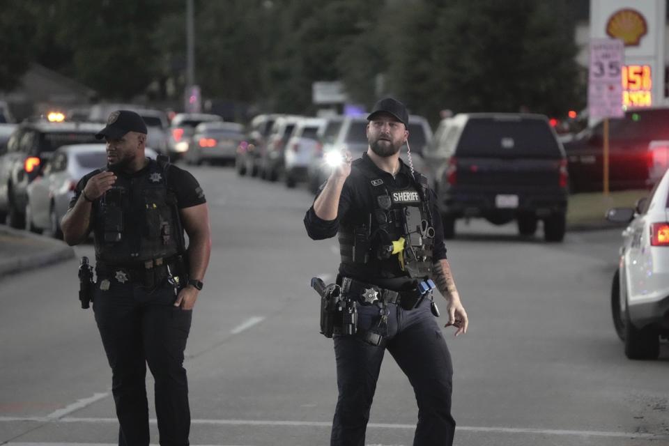 Law enforcement officers work the scene where an alleged shooting suspect is barricaded in a home in a subdivision in northeast Harris County, on Thursday, Aug. 17, 2023, in Houston. The standoff ensued after two law enforcement officers were shot Thursday evening confronting a person of interest in connection to Wednesday night's shooting of Harris County Sheriff's Deputy Joseph Anderson during a traffic stop, Harris County Sheriff Ed Gonzalez said. (Brett Coomer/Houston Chronicle via AP)