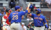 New York Mets' Jonathan Villar, right, is greeted by Tommy Hunter hitting a two-run home run, next to Atlanta Braves catcher William Contreras during the third inning of a baseball game Tuesday, May 18, 2021, in Atlanta. (Curtis Compton/Atlanta Journal-Constitution via AP)