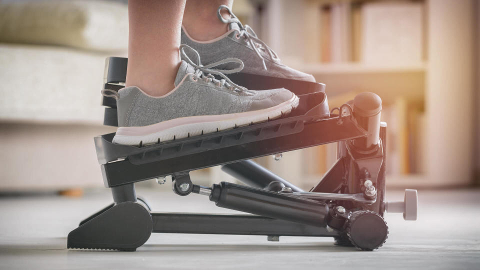 Woman doing exercises on stepper at home - Image.