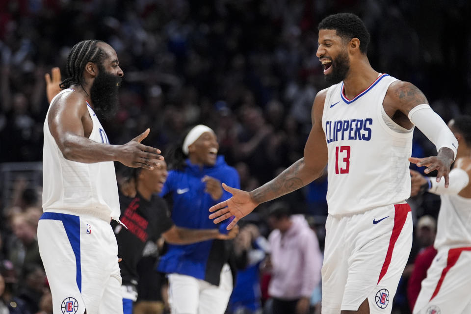 Los Angeles Clippers guard James Harden, left, and forward Paul George celebrate in the closing seconds of a win over the Brooklyn Nets during the second half of an NBA basketball game, Sunday, Jan. 21, 2024, in Los Angeles. (AP Photo/Marcio Jose Sanchez)