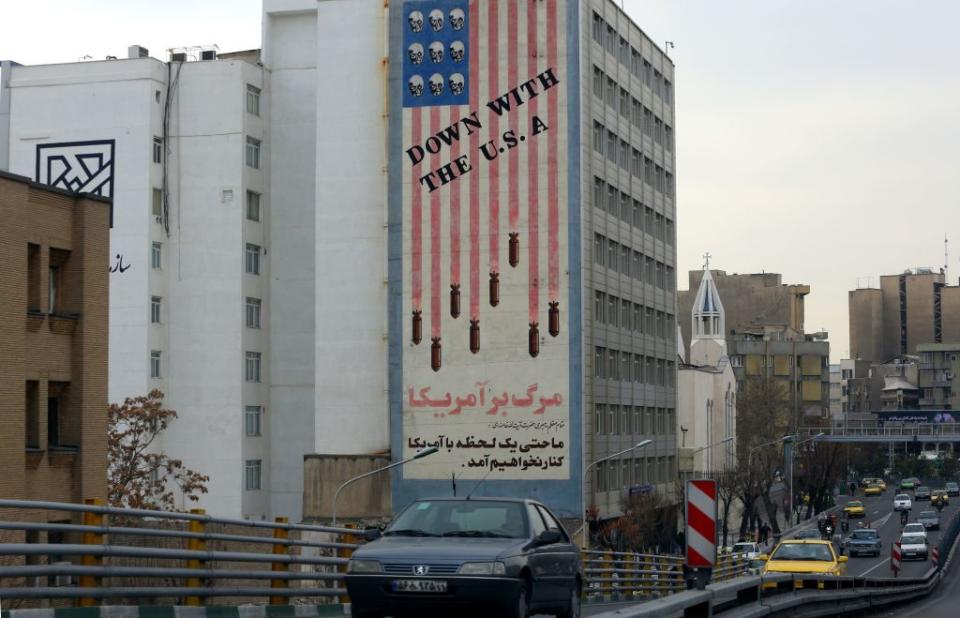 Cars drive past a mural painted on the wall of a building showing an anti US slogan in the capital Tehran on January 4, 2020. Source: Getty