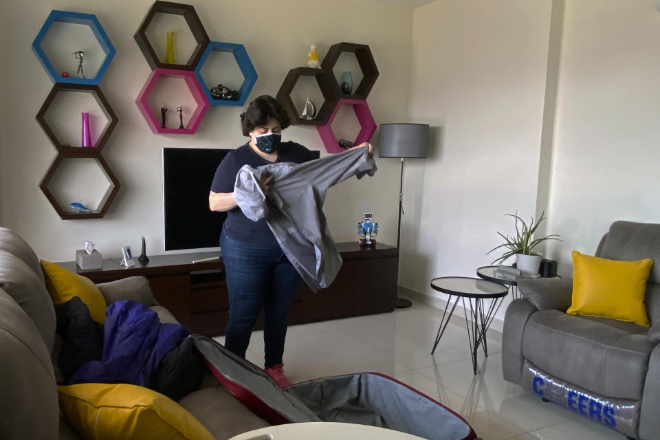 Pharmacist Rita El Khoury packs a suitcase at her apartment in preparation for her move to France with her husband, in Dbayeh, north of Beirut, Lebanon, Saturday, May 8, 2021. They are part of the latest wave of emigration in the small country’s tortured modern history, driven by financial ruin, collapsing institutions, hyperinflation and rapidly rising poverty. (AP Photo/Zeina Karam)