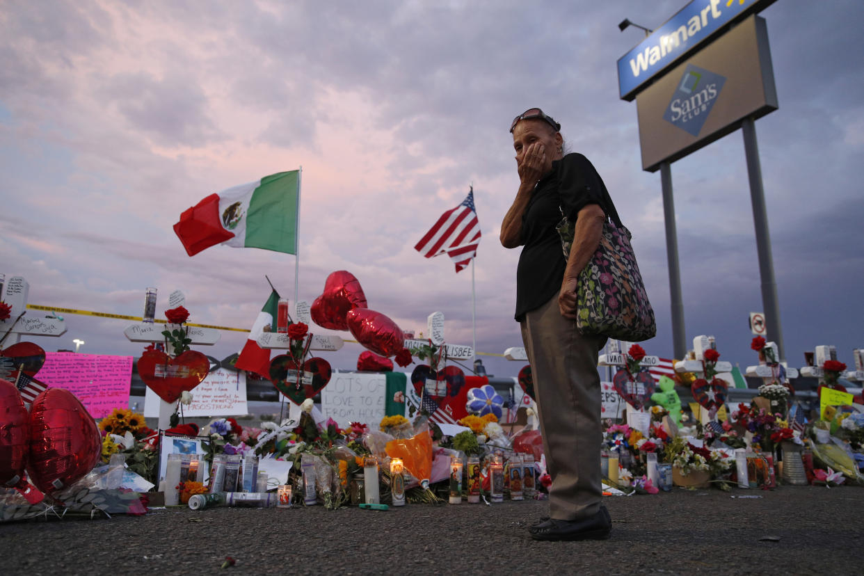 A woman wipes tears from her face as she visits a makeshift memorial near the scene of a mass shooting at a Walmart in El Paso, Texas, on Tuesday. (AP Photo/John Locher)